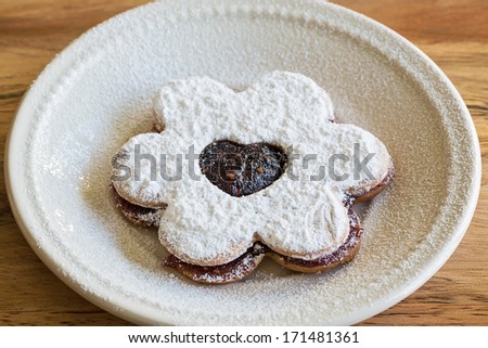cookie in the shape of a flower with a strawberry jam filling in the shape of a heart