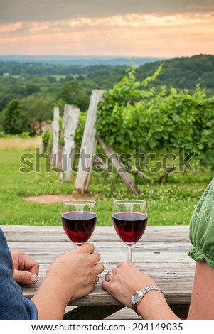 glasses of red wine held by a couple