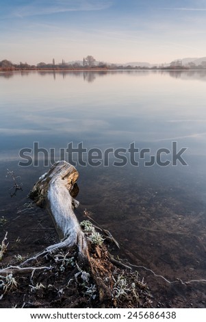 ATTENBOROUGH NATURE RESERVE, ATTENBOROUGH, ENGLAND - JANUARY 2, 2007: A frosty log protrudes out into the lake at Attenborough Nature Reserve, England on 2nd January 2007.