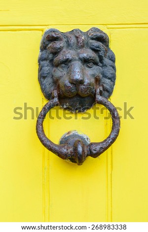NOTTINGHAM, ENGLAND - APRIL 12: A Lions head door knocker on bright yellow door. On 12th April, 2015, in Nottingham, England.