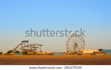 SKEGNESS, ENGLAND - JUNE 8: Skegness beach, the big wheel and the fair ground, early morning, in June. In Skegness, Lincolnshire, England on 8th June 2015.