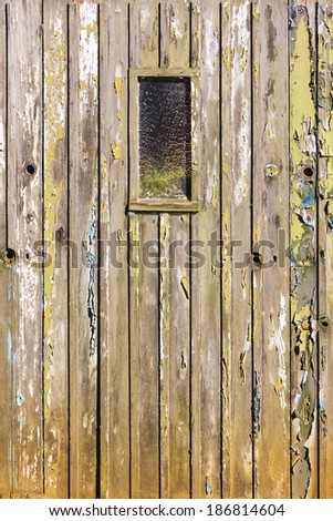Weather-beaten wooden door with peeling colored paint