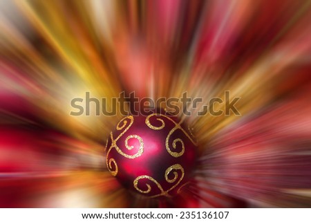 A box of Christmas decorations contains red and gold baubles, beads and stars with a star burst effect on the background decorations.