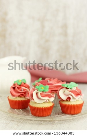 Red and white vanilla cupcakes and mini cupcakes on a plate
