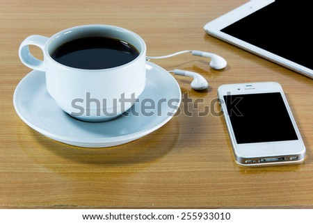 Digital tablet computer with  cup of coffee on old wooden desk. Simple workspace or coffee break with web surfing.