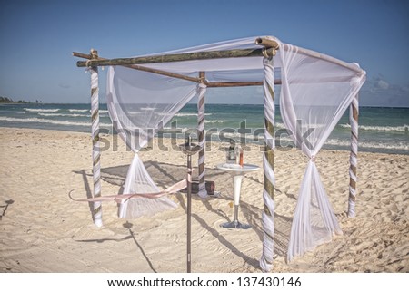 white wedding gazebo on caribbean beach with decorated table