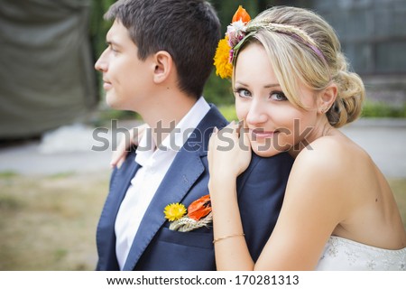 Young couple hug in wedding gown. Bride holding bouquet of flowers