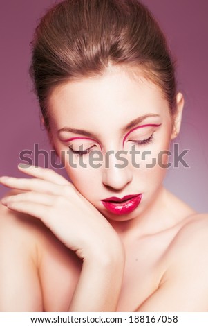 Beautiful brunette woman with red full lips and red lines on her eyelids and braid hairstyle and closed eyes
