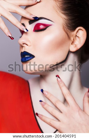 Beautiful brunette woman with creative pop art make up and geometric nail style, black lines and closed eyes