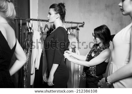 Plus size fashion models prepared for runway by stylish designer. Black and white photography