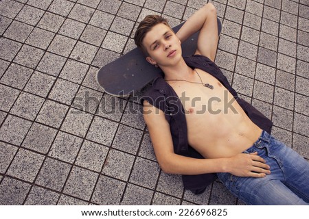 Young blonde guy on skateboard in casual outfit in the urban city outdoors. active. sport. copy space
