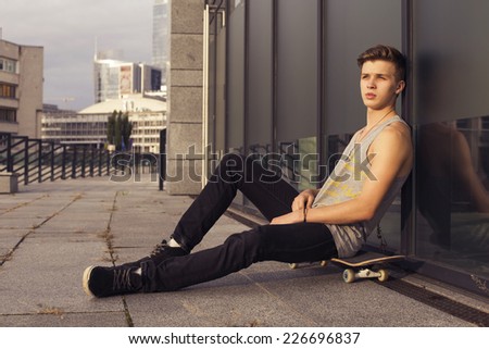 Young blonde guy on skateboard in casual outfit in the urban city outdoors. active. sport. copy space
