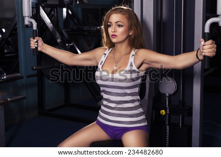 fit woman trains in gym. alone. one. indoors