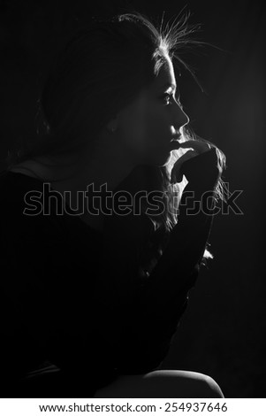 Beautiful woman in black sweater on black background. Black and White. Monochrome portrait. Dramatic. Sensual