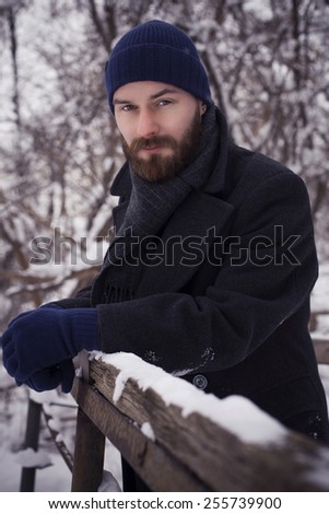 Handsome bearded man in jacket outdoors. Snow cold weather