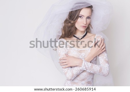 Brunette bide innocent nun woman in lace dress with a veil with a cross accessories, all wearing white. sensual portrait