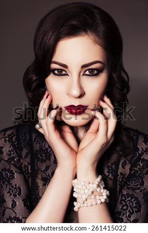Beautiful brunette woman in black dress with evening make up and waves retro  hairstyle. fashion posing