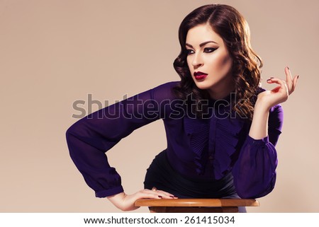 Beautiful brunette woman in dark skirt and blouse with evening make up and waves retro  hairstyle. fashion posing