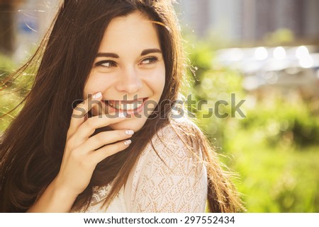 Beautiful brunette caucasian young woman laughing showing perfect teeth on summer sunny day. outdoors. nature. copy space