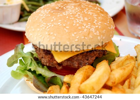 Cheese burger - Hamburger with cheese, fries for lunch in a cafe terrace