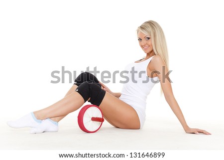 Beautiful sporty woman with roller slider sits on a white background. Fitness.