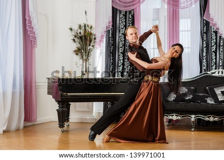 Dancing young couple in the room.