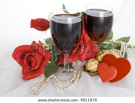 Red Rose, candies,  two glasses of wine, two hearts and a thread of pearls on a white background.