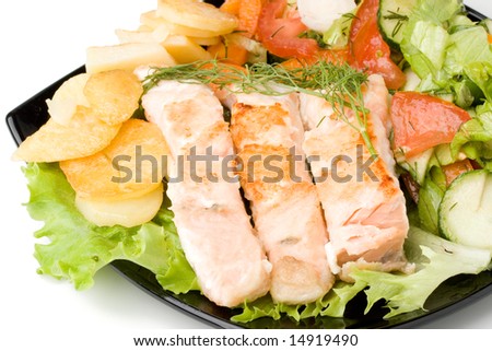 Stake from a salmon with vegetables on a plate. Closeup.