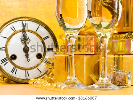 Decoration with an antique clock, firtree branch, gift boxes and champagne glasses