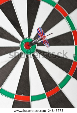 Dart on bull\'s eye of a dartboard. Close up. Selective focus.