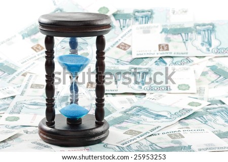 Hourglass standing on a floor from banknotes. Concept for time is money.