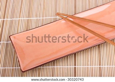 Asian plate with chopsticks on a bamboo mat