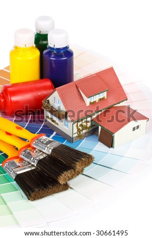 Various painting tools, miniature house and color guide on a white background