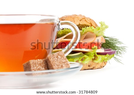 Ham sandwich and cup of tea on a white background. Selective focus. Close up.