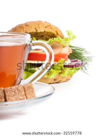 Ham sandwich and cup of tea on a white background. Selective focus. Close up.