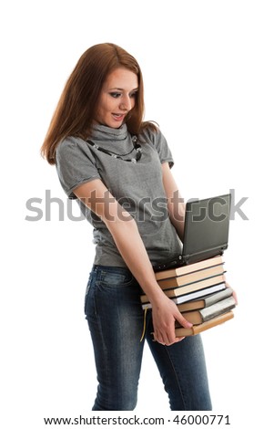 The attractive student stands with the laptop and books on a white background.