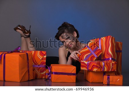 Beautiful young woman with pile of gift boxes.