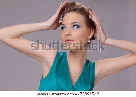 Portrait of the surprised young woman in turquoise dress.