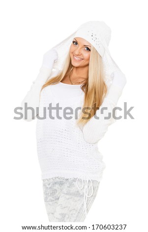 Young happy beautiful woman in winter clothes stands on a white background.