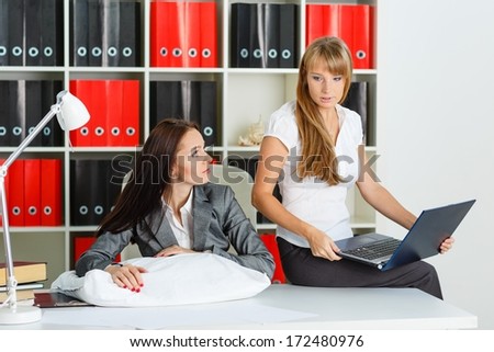 Tired young business woman is sleeping on workplace in the office, another employee took advantage of the situation and is stealing private information from computer of competitor.