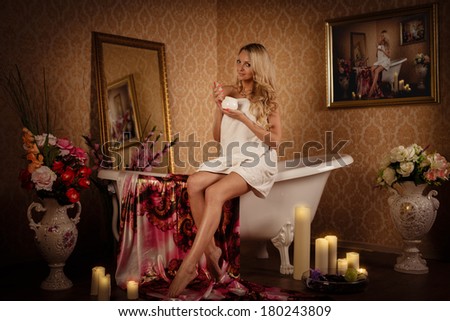 Young woman with cosmetic cream in a bathroom. Concept body care.