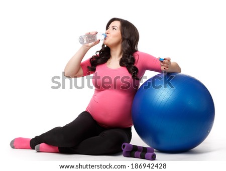 The active pregnant woman with gymnastic ball on a white background. Care of health and pregnancy.