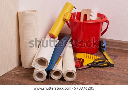 Still life from rolls of wall-paper and various tools for wallpapering. Repair. Home renovation.