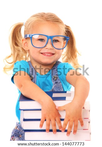 A picture of a young cheerful girl resting her arms on the pile of books against white background