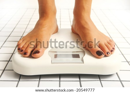 woman legs over white weight in bathroom