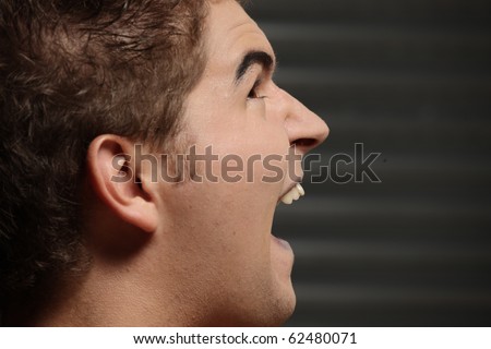 A picture of a male scarry vampire screaming over dark background