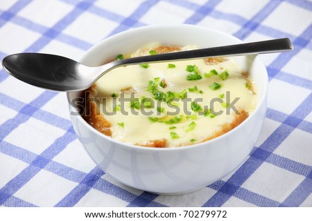 A picture of a bowl of fresh french onion soup baked with toast and cheese