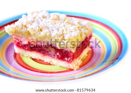 A picture of Polish traditional cake with redcurrant presented on a colorful plate over white background