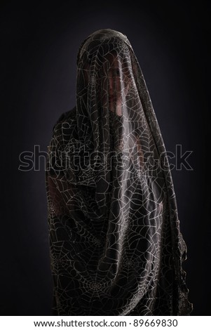 A picture of a mysterious person standing against dark background