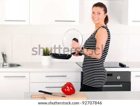 A picture of a happy wife preparing meal in the kitchen